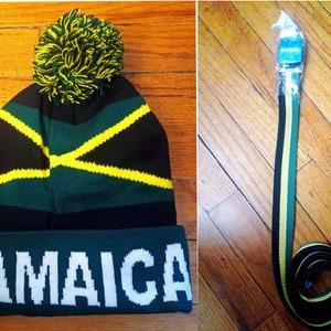 May include: A green, black, and yellow knit beanie with a pom pom on top. The beanie has the word "JAMAICA" written in white on the front.