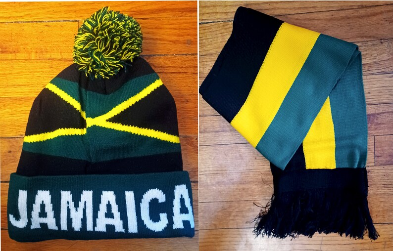 May include: A black, green, and yellow knit beanie with a pom-pom on top and the word "JAMAICA" written in white on the front. A matching black, green, and yellow striped scarf with black fringe.