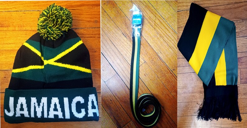 May include: A set of three Jamaican themed accessories: a black, green, and yellow knit beanie with a pom-pom, a black, green, and yellow striped belt, and a black, green, and yellow striped scarf with black tassels.