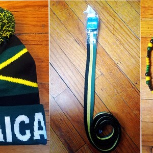May include: A set of three Jamaican themed accessories: a black, green, and yellow knit beanie with a pom-pom, a black, green, and yellow striped belt, and a black, green, and yellow beaded necklace with a Jamaican flag pendant.