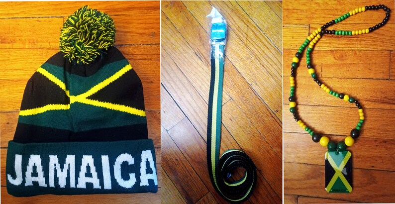 May include: A set of three Jamaican themed accessories: a black, green, and yellow knit beanie with a pom-pom, a black, green, and yellow striped belt, and a black, green, and yellow beaded necklace with a Jamaican flag pendant.