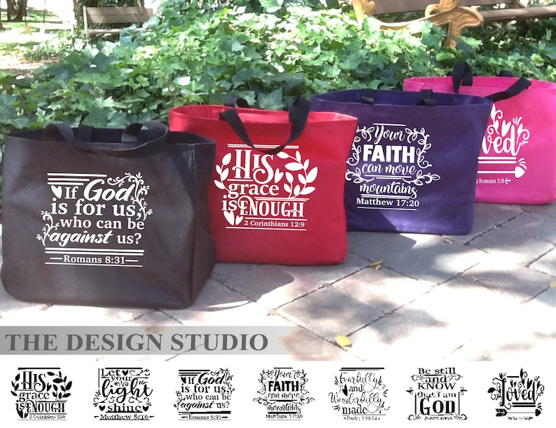 May include: A collection of tote bags in black, red, purple, and pink. Each bag features a white inspirational quote. The bags have black handles and are displayed outdoors. The text "THE DESIGN STUDIO" is at the bottom.