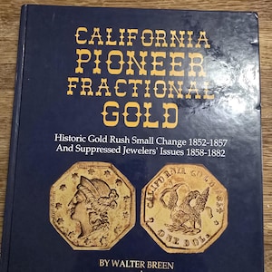 Puede incluir: Un libro azul oscuro titulado "CALIFORNIA PIONEER FRACTIONAL GOLD" con letras doradas. La portada presenta imágenes de monedas de oro y detalla la historia de la época de la fiebre del oro, incluyendo el cambio pequeño y los problemas de los joyeros.