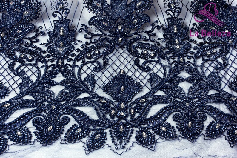 May include: Navy blue beaded lace fabric with a floral design. The lace is embellished with small, round beads and clear rhinestones.