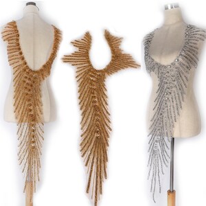 May include: Two beaded embellishments for clothing, one gold and one silver. Both are long and narrow, with a pointed tip and a V-shaped neckline.