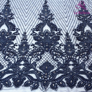 May include: Navy blue beaded lace fabric with a floral design. The fabric has a delicate, intricate pattern with small beads and sequins.