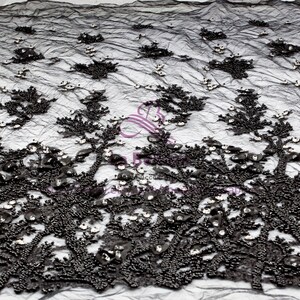 May include: Black beaded lace fabric with a floral design. The fabric is embellished with small, shiny sequins.