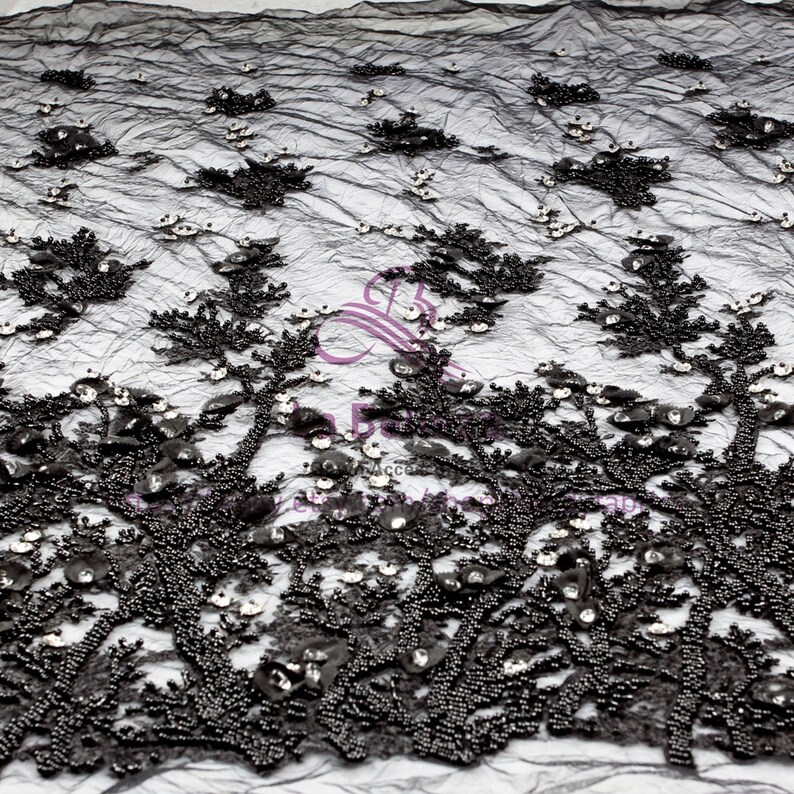 May include: Black beaded lace fabric with a floral design. The fabric is embellished with small, shiny sequins.