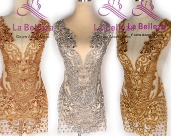 May include: Three beaded embellishments for gowns, one gold, one silver, and one gold. The embellishments are on mannequins and feature a floral design.