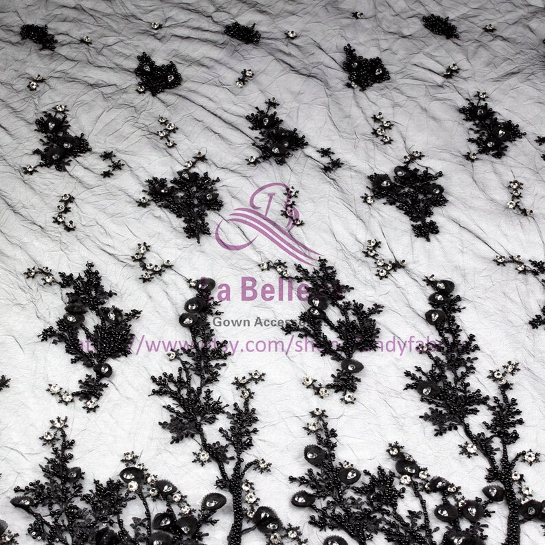 May include: Black beaded lace fabric featuring floral patterns and small, clear rhinestones. The fabric is sheer and delicate, with a soft, flowing texture.