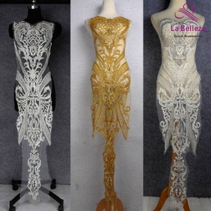May include: Three beaded lace appliques for a gown or dress. The appliques are shown on dress forms. One applique is white, one is gold, and one is silver.