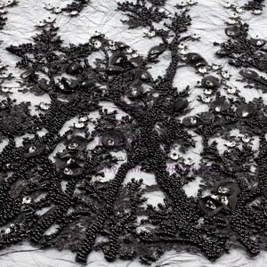 May include: Black beaded lace fabric with a floral design. The fabric is embellished with small black beads and clear rhinestones.