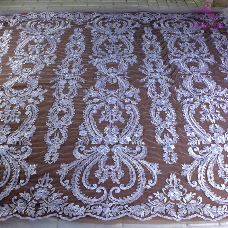 K&ouml;nnte beinhalten: Wei&szlig;er Spitzenstoff mit Blumenmuster. Der Stoff hat ein zartes, filigranes Design mit kleinen wei&szlig;en Bl&uuml;ten und Bl&auml;ttern.