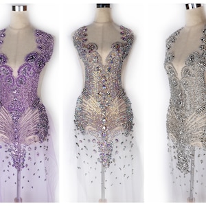 May include: Three embellished bodice appliques in purple, iridescent, and silver. Each features a detailed beaded design with a plunging neckline and a flowing, feather-like pattern. The appliques are displayed on dress forms.