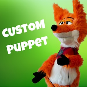May include: An orange and white fox puppet with black hands and a red, green, and blue plaid neckerchief. The puppet has large eyes, a black nose, and tall, furry ears. The text "CUSTOM PUPPET" is printed in large white letters on the left side.