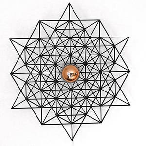 May include: A black metal geometric wall sconce with a round, copper-colored light fixture in the center.