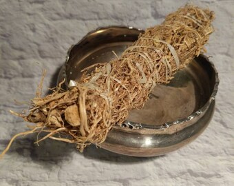 May include: A bundle of dried roots tied together with twine, resting in a silver bowl. The roots are light brown and have a natural, earthy texture.