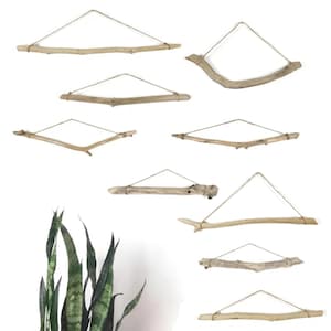 May include: A collection of driftwood wall hangings. Each piece is made from natural wood, suspended by twine, and arranged in various geometric shapes. The wood tones range from light beige to medium brown.