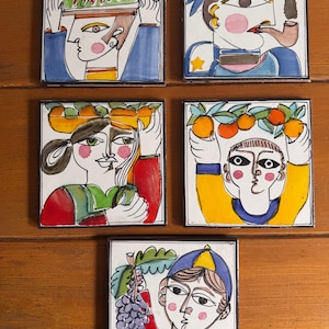 May include: Five square ceramic tiles with colorful illustrations of people carrying various items. The tiles feature a person with a fish, a sailor with a pipe, a person with fruit, a person with oranges, and a person with grapes.