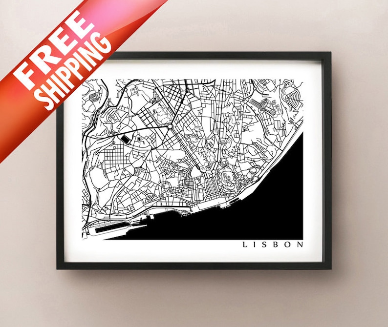 May include: A framed black and white map print of Lisbon, Portugal. The city map is detailed with streets and buildings, with the word "LISBON" at the bottom. The print is in a black frame.