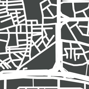 May include: A stylized, abstract map design in white lines against a dark gray background. The map features a network of roads and streets, creating a geometric pattern. The design is simple and modern.