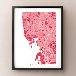 May include: Framed print featuring a detailed map of Jeddah in a vibrant red hue against a white background. The city map is intricately designed, showcasing streets and landmarks. The word "JEDDAH" is printed in a clean font at the bottom.