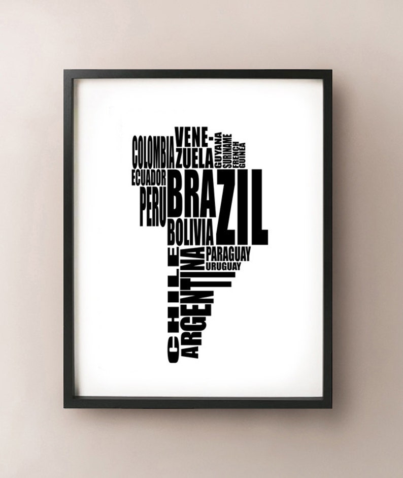 May include: Black framed print featuring a stylized map of South America. The continent's shape is formed by the names of its countries in black text against a white background. The word "Brazil" is prominently displayed.