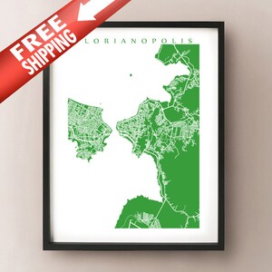 May include: A framed green and white map of Florianopolis, Brazil. The map is a detailed outline of the city's streets and neighborhoods. The words "Florianopolis" are printed in green at the top. The frame is black.