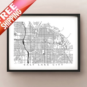 May include: Framed black and white map print of Salt Lake City, featuring a detailed street grid. The text "SALT LAKE CITY" is at the bottom. A red banner in the upper left corner reads "FREE SHIPPING".
