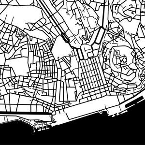 May include: A black and white line art map depicting a city's intricate street layout. The design features a dense network of roads, buildings, and urban elements, with a contrasting black and white color scheme. The map includes a waterfront area.