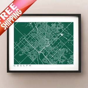 May include: A framed print of a map of Guelph, Ontario, Canada, in white lines on a dark green background. The city name is printed in white at the bottom. The print is in a black frame. A red banner with white text that says "FREE SHIPPING" is in the upper left corner.