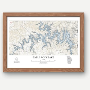 May include: A framed map of Table Rock Lake in Missouri. The map shows the lake's shoreline and surrounding area in detail. The map is printed on white paper with blue and brown accents. The frame is made of wood and has a natural finish.
