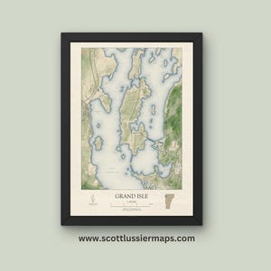 May include: A vintage-style map of Grand Isle, Vermont, with a black frame. The map shows the island's coastline, waterways, and surrounding land. The map is printed on a cream-colored paper with brown and blue ink.