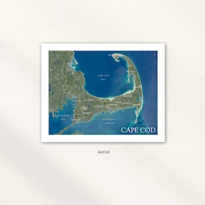 May include: An aerial view of Cape Cod, Massachusetts, framed in a white border. The map shows the peninsula's shape, with the Atlantic Ocean on one side and Cape Cod Bay on the other. Text includes "Cape Cod" and place names.