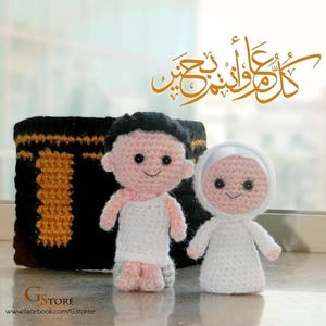 May include: Crocheted dolls of a man and woman in white garments, with black hair and smiling faces. A black and gold crocheted structure is behind them. The image includes Arabic calligraphy in gold and the text "GStore".
