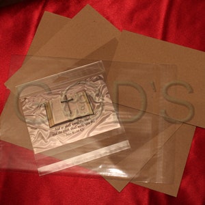 Puede incluir: Una bolsa de pl&aacute;stico transparente con un respaldo de papel marr&oacute;n. La bolsa contiene una tarjeta con una imagen de un libro abierto con una cruz en la parte superior. La tarjeta tiene el texto "Y conocer&eacute;is la verdad, y la verdad os har&aacute; libres." Juan 8:32 KJV.
