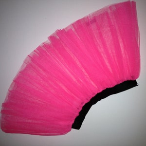 May include: A bright pink tulle skirt with a black elastic waistband.