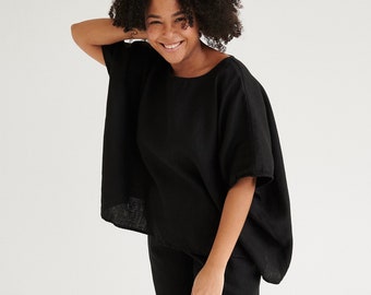 May include: A woman wearing a black linen top and matching pants. The top has a relaxed, oversized fit and short sleeves. The pants are straight-leg and cropped.