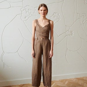 May include: A brown linen wrap top and wide-leg pants set. The top has a V-neckline and a wrap closure at the waist. The pants have a high waist and a wide leg.
