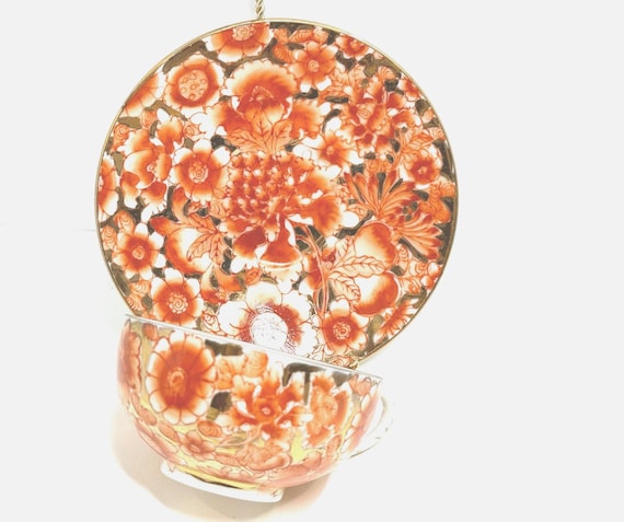 Asian Teacup and Saucer: Orange and Gold Design