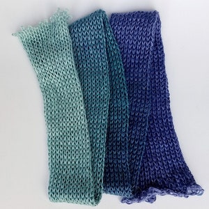 Pode incluir: Tr&ecirc;s tiras de tecido de malha em tons de azul e verde. O tecido &eacute; um degrad&ecirc; de verde claro para azul escuro.