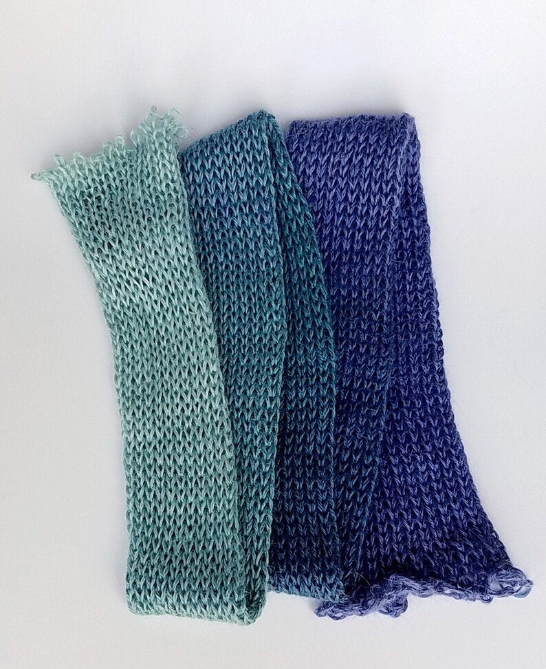 Pode incluir: Tr&ecirc;s tiras de tecido de malha em tons de azul e verde. O tecido &eacute; um degrad&ecirc; de verde claro para azul escuro.