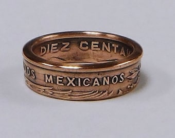 May include: A copper-colored ring made from a Mexican coin. The ring features the inscription "DIEZ CENTAVOS MEXICANOS".
