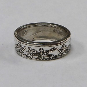 May include: A silver ring made from a 50-cent coin. The ring features the inscription "50 CENTS" and a crown.