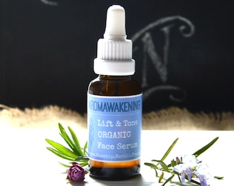 May include: A brown glass bottle with a white dropper top and a blue label that reads "Aromawakening Lift & Tone Organic Face Serum Rosehip, Neroli, Frankincense".