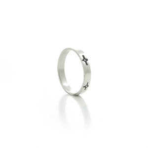 May include: A silver band ring with a simple design of four small crosses around the band.