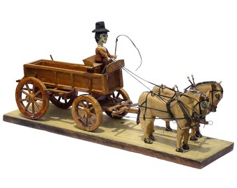 A detailed carved assemblage of a man driving two horses and a wagon. The man has jointed arms and legs, pins for eyes. (Offers Considered)