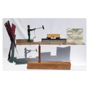 A whirligig of John Henry working on the railroad. The carved, jointed figure goes up and down, hammering on the track. (Offers Considered)
