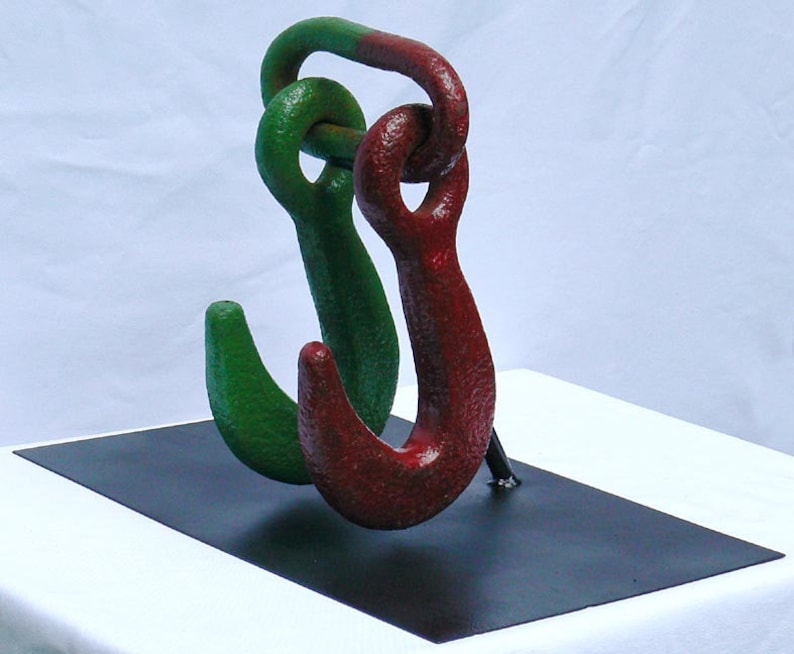 Movable metal sculpture made of two huge old iron hooks connected through a link Offers Considered Great Paint and Color.