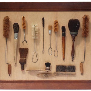An unusual and decorative framed collection of brushes. There is a wide variety of styles, types, and materials.  (Offers Considered)